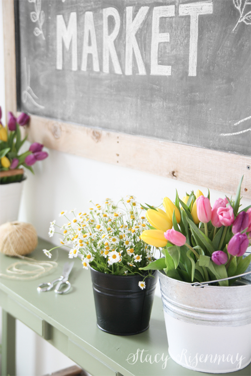 spring flowers in buckets on entry table