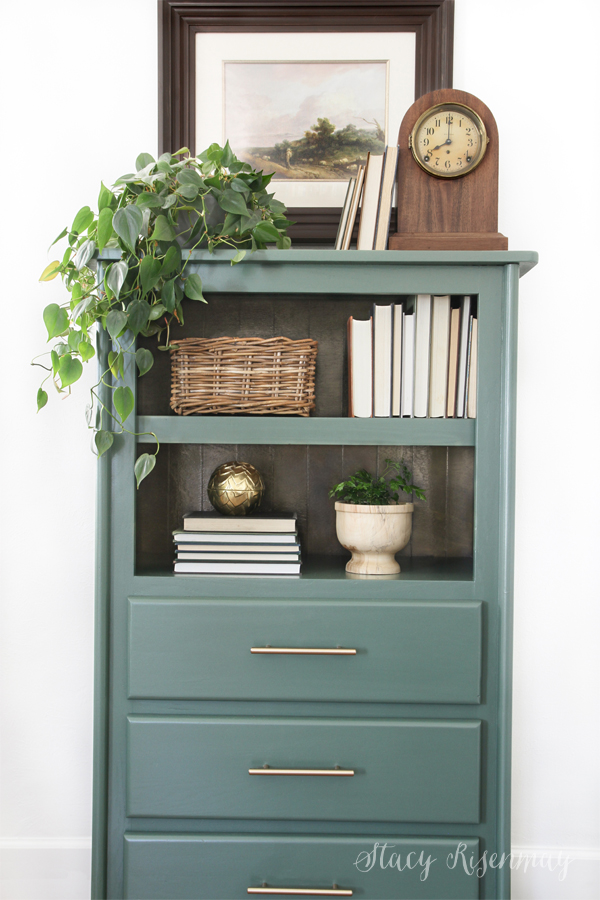 a styled armoire with books and plants