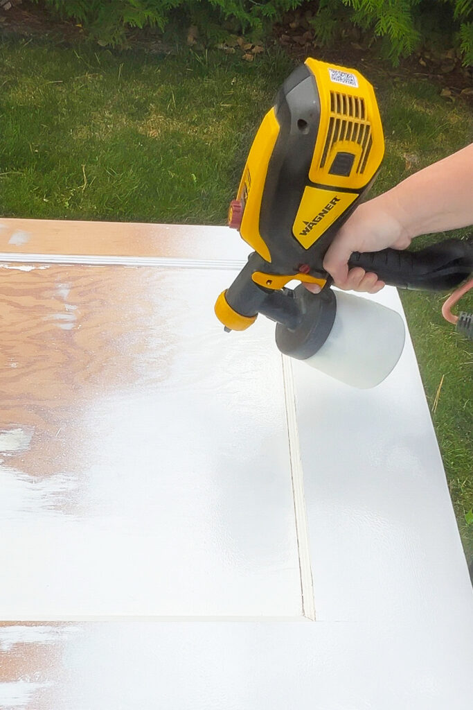 priming a door with a paint sprayer