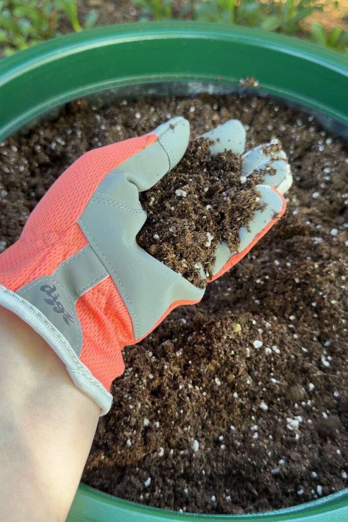 adding fresh dirt to a large outdoor planter
